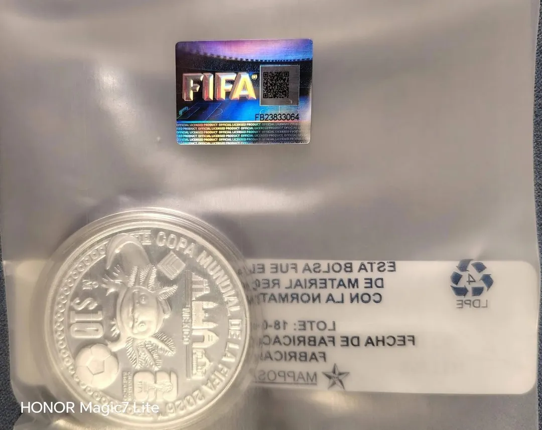 Reverso onza con mascota oficial Maple en relieve, ceca Mo, valor $10, holograma FIFA Official Licensed Product con QR