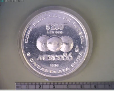 200 Pesos Copa Mundial México 86 (Plata .999, 2 onzas) (reverso, un balón entre dos hemisferios del planeta, con la leyenda LEY 999 · 2 ONZAS PLATA PURA)